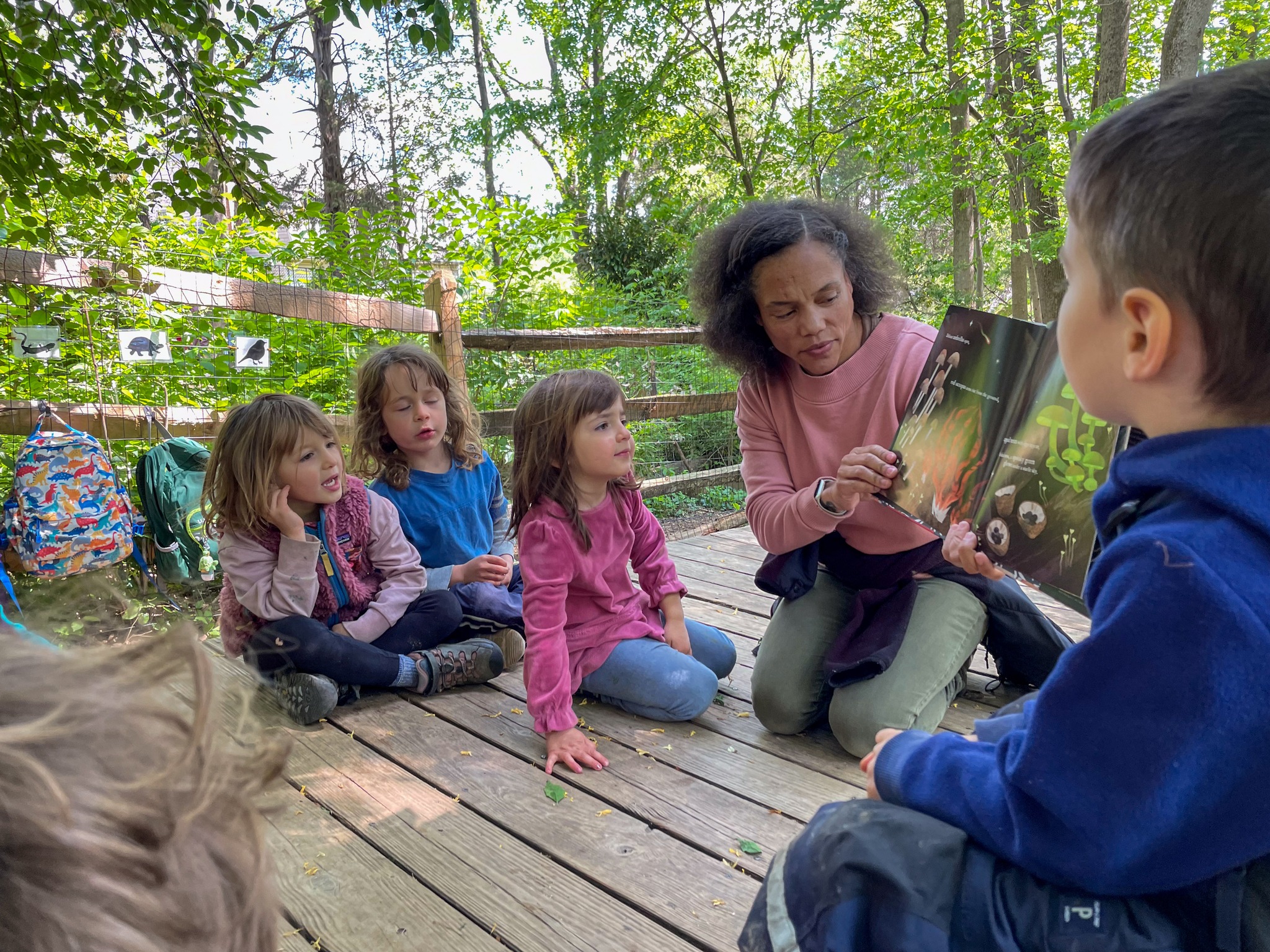 teacher reading to preschoolers outside